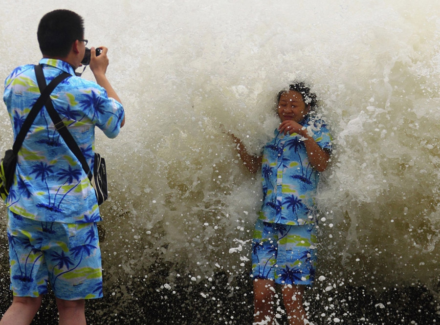 30 сентября, Санья, провинция Хайнань, Китай. Туристы фотографируются на берегу моря во время шторма, вызванного тайфуном Вутип