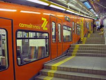 Метро. Станция &quot;Масада&quot;. Поезд / Метро в Хайфе, 6 станций, все станции с наклоном, но наклон везде разный, есть 2 почти горизонтальные станции, и в тех местах, где тут по пять-6 ступенек там по 1й,
и сидя в поезде создаётся впечатление обратного наклона, на этой станции , как вы видите поезд горизонтален(с точки зрения пассажиров).
А на самой верхней станции наклон таков, что между площадками сплошные ступеньками