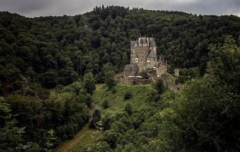 Замок Эльц / Замок Эльц (нем. Burg Eltz) — замок в земле Рейнланд-Пфальц близ Виршема в долине реки Эльцбах, отделяющей Майфельд от предгорьев Айфеля. Замок Эльц считается наряду с дворцом Бюрресхайм единственным сооружением в Айфеле, которое никогда не подвергалось захвату и не было разгромлено. Замок уцелел даже во время войн XVII и XVIII вв. и потрясений Французской революции.
Замок в долине речушки под названием Эльц был построен предположительно в XII веке. Замок сохранился и до настоящего времени. С трёх сторон замок окружён рекой и возвышается на скале высотой в 70 метров. Вокруг замка замечательный ландшафт.