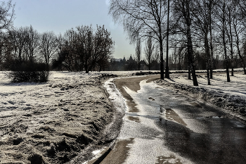 Весенняя дорога в парке Коломенское / Весна, снег тает образуя лужи на дороге