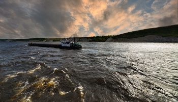 По Волге реке. / Плывет баржа по Волге откуда-то туда , и плещется накатами прибойная вода