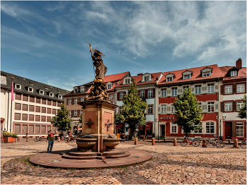 Корнмаркт со статуей Мадонны/Heidelberg, Germany/ / Статуя Мадонны на Корнмаркте была возведена в ходе рекатолизации при курфюрсте Карле Филиппе.
Созданная Петером фон ден Бранденом в 1718 году Мадонна на кукурузном рынке считается самой красивой статуей в стиле барокко в Гейдельберге.
На западной стороне площади Корнмаркт стоит величественный Дворец принца Карла — с 1788 года гостиница, до 1915 года один из ведущих отелей Гейдельберга,
сегодня место проведения мероприятий с великолепным Зеркальным залом, — а в дальнем восточном углу — бледно-желтый дом Французский граф де Граймберг.
Шарль де Граймберг по собственной воле и огромными усилиями стал консерватором замка и основателем городских коллекций произведений искусства.
Граймберг умер в 1864 году, дожив до своей мечты о сохранении замка.