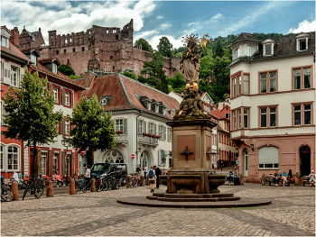 Корнмаркт со статуей Мадонны/Heidelberg, Germany/ / Всего в нескольких минутах ходьбы от Рыночной площади расположена еще одна историческая площадь Гейдельберга - Корнмаркт. Среди жителей города широко распространено мнение о ней, как о самой красивой городской площади. Исторически именно здесь располагался рынок зерна, а в 1717 году был возведен Дворец великих герцогов Баденских. Бывшая резиденция герцогов, выполненная в стиле классицизма, является главной архитектурной доминантой площади, в наши дни здесь размещена Академия наук. Почти одновременно со строительством дворца появился и живописный фонтан работы, увенчанный статуей Мадонны в окружении ангелов. Она была установлена как знак, символизирующий стремление обратить непокорных протестантов в истинную веру после Контрреформации. Кроме того, с площади Кронмаркт на фуникулере можно добраться до вершины горы Кёнигштуль.