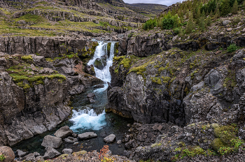 Безымянный водопад / Безымянный водопад.
Может быть у него и есть название, но очень уж он типичный для Исландии и явно в 10-ку или даже 20-ку лучших не входит ни по каким параметрам. Высота метров 5-6, течет по лавовым нагромаждениям. Зато вода в нем вкусная, тем и запомнился.