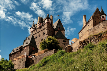Замок Эльц / Замок Эльц (нем. Burg Eltz) — замок в земле Рейнланд-Пфальц близ Виршема в долине реки Эльцбах, отделяющей Майфельд от предгорьев Айфеля. Замок Эльц считается наряду с дворцом Бюрресхайм единственным сооружением в Айфеле, которое никогда не подвергалось захвату и не было разгромлено. Замок уцелел даже во время войн XVII и XVIII вв. и потрясений Французской революции. Замок в долине речушки под названием Эльц был построен предположительно в XII веке. Замок сохранился и до настоящего времени. С трёх сторон замок окружён рекой и возвышается на скале высотой в 70 метров. Вокруг замка замечательный ландшафт.
