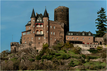 Замок Катц (нем.Burg Katz) / Замок Катц (нем.Burg Katz) стоит на выступе скалы на берегу реки в прекрасной Долине Среднего Рейна. Из окон и со стен замка открывает завораживающий вид на окрестности и прекрасную долину Рейна, внесенную Юнеско в список Всемирного наследия. Недалеко от замка Катц находится его собрат, замок Маус (нем.Burg Maus), а на противоположном берегу расположены руины крепости Райнфельс (нем.Burg Rheinfels). Замок Катц был построен около 1371 года по распоряжению графа Вильгельма II Катценельнбогена (нем.Wilhelm II Katzenelnbogen), который назвал его своим именем – Катценельнбоген. Это название показалось народу слишком трудным и замок стали называть Катц (Кошка).