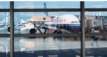 Самолёт на посадку / Самолёт в аэропорту через стекло с отражениями