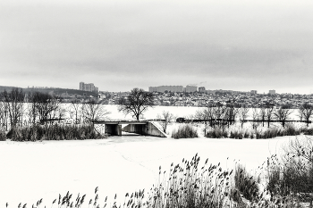 В черно-белом / Городской вид на берегу. В стиле Dark Sepia - черно белое. Утром в феврале пасмурно. Берег, с возвышенности, заводь, мостик. За ним водохранилище. На противоположном берегу город..