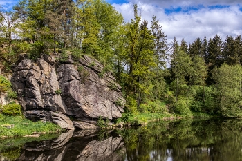 &nbsp; / bewachsener Kletterfelsen spiegelt sich im Fluss