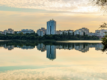 Утром город после рассвета.. / Городской пейзаж утром. С берега водохранилища. При контровом свете.. Отраженный в водной глади водохранилища городской массив..