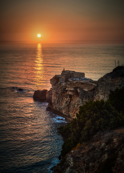 напротив солнца / маяк Назаре, Португалия