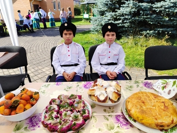 На празднике / парни из ансамбля за столом с явствами )