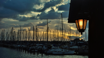 Всё ярче горит одинокий фонарь... / На фоне догорающего заката и в ночь уходящего пирса.