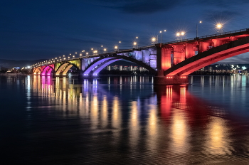 Коммунальный мост / Коммунальный мост входит в число главных достопримечательностей Красноярска не только потому, что миллионы жителей России видели его изображение на лицевой стороне десятирублёвой купюры и мечтают вживую увидеть мост во всей красе особенно в вечернее и ночное время, когда семь режимов иллюминации создают захватывающее световое шоу.