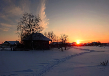 «Зимние сумерки в Сибирской глубинке» / В деревне закат — как старый альбом, Где детство живёт за каждым углом. Снег укрыл дома, как пуховое одеяло, Солнце садится — тихо, не спеша, бывало. Тропа зовёт в далёкий край мечты, Где нет забот, где счастливы мы. Деревья стоят, как стражи во мгле, В их ветвях — вся прелесть в тишине...