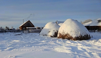 «Зимний антракт деревенской жизни» / Стога спят под белым пледом, Дома дремлют в тишине. В зимнем царстве, в тихом свете Всё укрыто в снежной мгле. Дым из трубы, как призрак тонкий, Танцует в холоде седом. И кажется, что мир спросонок Застыл в волшебном сне своём.