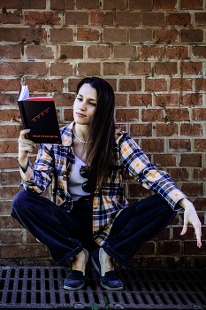 Люда. Принципы / Девушка на фоне кирпичной стены, сидя на корточках читает книгу