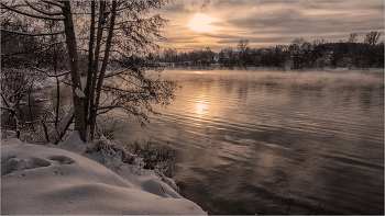 В вечерних тёплых тонах января... / Морозный январский день на реке, заходящее Солнце, туман над водой.