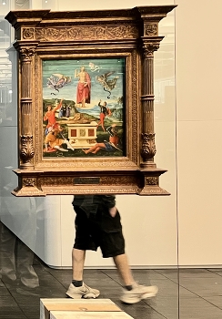 &nbsp; / A man walking past an old master’s piece displayed on a glass wall in Săo Paolo Museum of Art, Brazil