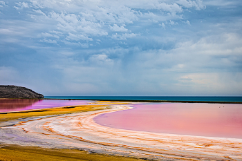 Кояшское озеро / Озеро отделено от моря тонким перешейком (видно на фото). Цвет - не оптическая иллюзия, а результат деятельности особых микроорганизмов. Иловые отложения имеют самый разный цвет: фиолетовый,жёлтый, голубой, зелёный....Озеро покрыто тонкой коркой соли и сантиметров 5-10 воды, по нему можно ходить, максимальная глубина до одного метра. Яркий малиново-красный цвет не всегда насыщенный, это зависит от времени года и погоды.
Респ.Крым Россия.