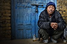 Enjoying... / Drunk man sitting near the blue door in Kathmanu Nepal, Asia