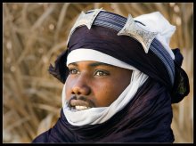 Туарег из Нигера.... / Этого молодого туарега в национальном костюме кочевника из Нигера, я сфотографировала в оазисе Ливии,среди безбрежного моря песка.
Он приехал туда продавать сувениры...

Туареги-кочевой народ Сахары.
Раньше их называли людьми с "синими лицами", так как национальный костюм туарега включает материю,крашенную индиго. Правила поведения каждого мужчины,предписывают ему закрывать лицо и покрывать голову таким *синим* шешем....
Когда шеш открыт,довольно часто можно увидеть *синии пятна от индиго* на лице настоящего туарега...

фото-тур Ю.Пустового.