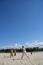 Мальчик в белых штанах на переднем плане среди играющих в фрисби на днепровском пляже / ***
