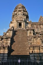 башня Ангкора. / Храм Ангкор-Ват (&quot;Город-храм&quot;) - самый известный памятник на территории Ангкора, недаром его строили в течение 30 лет (1112-1142 гг.). Ангкор- Ват также считается и самой большой культовой постройкой в мире. Храм был построен королем Сурьяварманом II и посвящался богу Вишне. Ангкор-Ват также был и гробницей Сурьявармана. Высота храма от основания до вершины центральной башни 213 метров. Комплекс состоит из центральной башни (около 66 м) и четырех башен поменьше вокруг нее, которые символизируют все вершины священной горы Меру. Центральная постройка храма - сложная конструкция с огромным количеством переходов и лестниц. Храм окружен рвом шириной 190 м. и длиной около 6 км и крепостной стеной с четырьмя воротами по всем сторонам света. На стенах внешней галереи видны длинные барельефы с изображениями Вишну, героев Рамаяны и сражений Сурьявармана II.