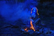 Общение с духами / Девушка в костюме индейца сидит у костра