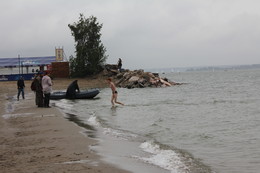 У природы нет плохой погоды / В дождливый День Российского флага на пляже в Новосибирске молодой человек устроил праздничный заплыв. Красивая девушка наблюдала за ним с гряды камней.