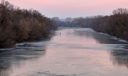 Отражение заката / Солнце почти спряталось за горизонт, но на противоположной стороне розовый цвет осветил небо и отразился на зеркальном льду реки.