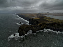 Мыс и маяк Дюрхолаэй (Исландия) / В коротком 15-минутном перерыве между двумя дождями я рискнул взлететь, несмотря на довольно сильный порывистый ветер, чтобы заснять живописную арку этого мыса.