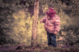 Любопытство / Двухлетняя девочка разглядывает березу в парке.