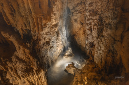 небольшой водопад в карстовой пещере / карстовая пещера в Португалии