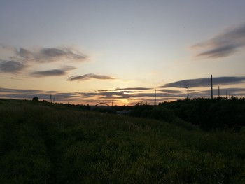 Закат / Закат в поле рядом с рекой, который заполонили облака