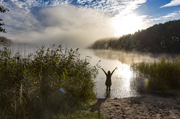 &nbsp; / Eine Frau genießt den Morgen am See vor der aufgehenden Sonne im Morgennebel