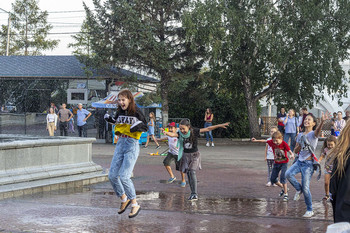 Водные процедуры / Дети бегают под брызгами воды от фонтанов.