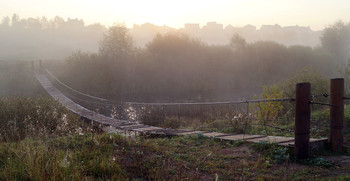 На рассвете / Сентябрьское туманное утро. Тихо, прохладно, безлюдно... Тысячи паутинок на лугу. Едва заметно плывет пелена тумана над речкой. Подвесной мостик отдыхает в тишине. Наступает новый день...