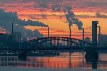 Финляндский железнодорожный мост на рассвете / осенний рассвет над Невой. Электричка едет по Финляндскому железнодорожному мосту и везет людей на работу. Ударили морозы и река потихоньку встает, вода зеркалится а дымы клубятся.
