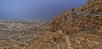 Масада / На вершине одной из скал Иудейской пустыни, поднимающейся на 450 м над Мёртвым морем, в 25 г. до н. э. царь Ирод I Великий, потомок идумеев, принявших иудаизм, построил убежище для себя и своей семьи, значительно укрепив и достроив существовавшую на этом месте крепость хасмонейского периода постройки 37-31 гг. до н.э.Со всех сторон Масаду окружают отвесные скалы. Лишь со стороны моря наверх ведет узкая, так называемая змеиная тропа. Вершину скалы венчает почти плоское трапециевидное плато, размеры которого примерно 600×300 м.В 66 г. н. э. Масада была взята восставшими зелотами, римский гарнизон был вырезан.
В 67 г. н.э в Масаде обосновались, представители радикальной партии, возглавившей восстание против римлян, вылившееся в длительную Иудейскую войну.
В 70 г. н.э, после взятия римскими легионами Иерусалима, Масада оказалась последним оплотом восставших. Защитников крепости едва насчитывалось около 1 тыс. человек, включая женщин и детей, но они удерживали Масаду еще 3 года.
Когда римлянам удалось поджечь дополнительно выстроенную сикариями внутреннюю оборонительную стену, состоящую из деревянных балок, участь Масады была решена.