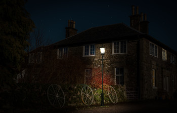 &nbsp; / Composition of a night shot showing three cart wheels illuminated by an old gas lamp post.