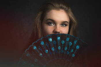 &nbsp; / Portrait shot of the lovely Chloe looking out from behind a hand fan.