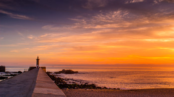 &nbsp; / Sunset on Porto's beach with Lighthouse on background