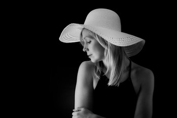 &nbsp; / Profile shot of Millie modeling a large brimmed white hat.