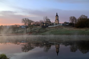 Нежный рассвет у реки в деревне / Нежное рассветное время на берегу реки. Прекрасные виды на сельскую церковь, деревья и отражения в тихой глади воды.