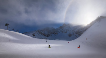 На лыжных трассах Чимбулака свечение гало. / Лыжники на лыжных трассах Чимбулака под Алматы вечером после снегопада. 
В горах свечение &quot;гало&quot;.