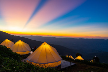&nbsp; / Camping and white tent on the hill with crepuscular rays after sunset background, Chiangrai Thailand