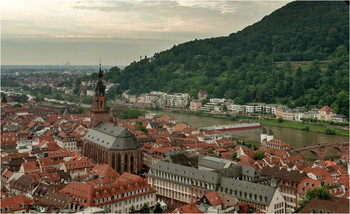 Heidelberg, Germany /Вид из замка на Старый город/ / Хайдельберг воплощает всё, что входит в понятие хорошего немецкого города. Небольшой, уютный, с хорошим среднем уровнем дохода, город. Стоит на реке, есть древний каменный мост и крепость. Над городом доминируют шпили церквей. В месте, где река Некар впадает в Рейн, расположен один из крупнейших промышленных центров южной Германии. В треугольнике Маннхайм - Хайдельберг - Карлсруэ сконцентрирована промышленная мощь земли Баден-Вюртемберг. И если Маннхайм имеет репутацию рабочего города с проблемным отношением к иммигрантам, то расположенный в 20 км к востоку от него Хайдельберг известен на всю Германию как старейший университетский город и один из передовых научных центров страны.
